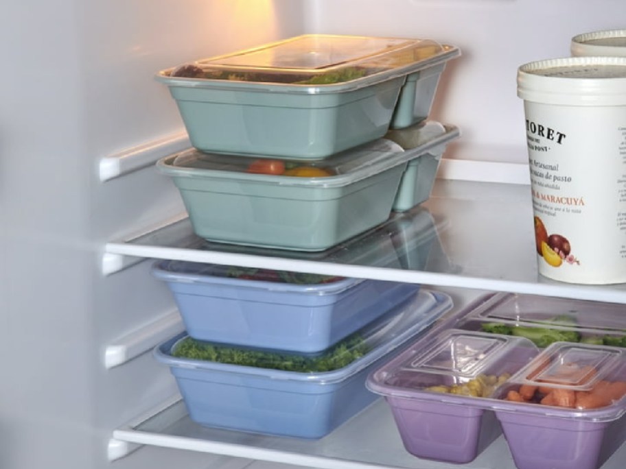 green, blue and purple food storage containers stacked in fridge