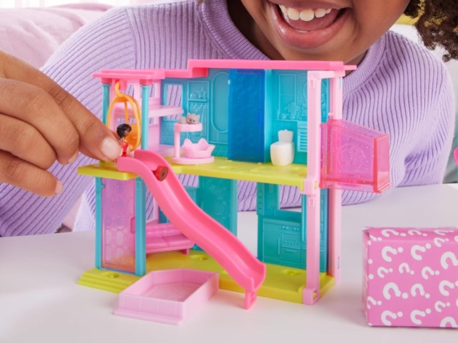 little girl playing with a mini BarbieLand toy Dreamhouse set