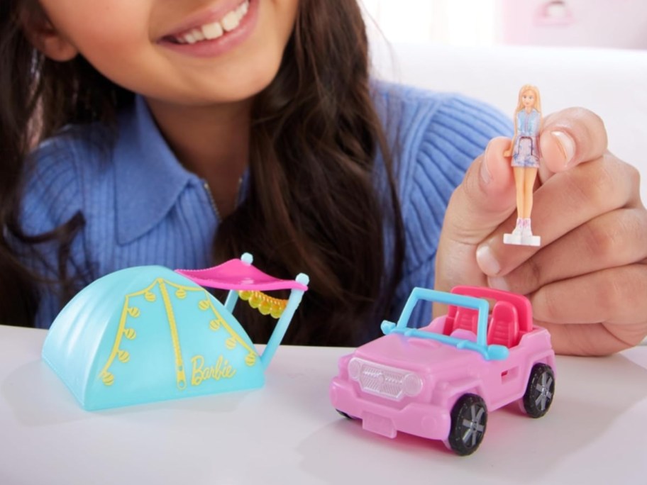 little girl playing with a mini BarbieLand toy Jeep