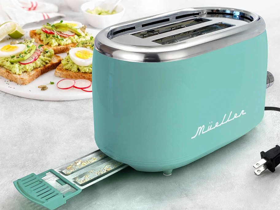 teal retro toaster with crumb tray pulled out