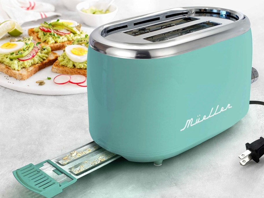 teal retro toaster with crumb tray pulled out