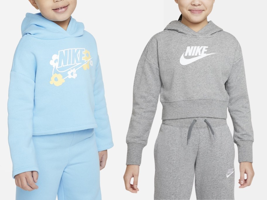 little girl wearing a light blue Nike hoodie next to a girl wearing a grey cropped Nike hoodie