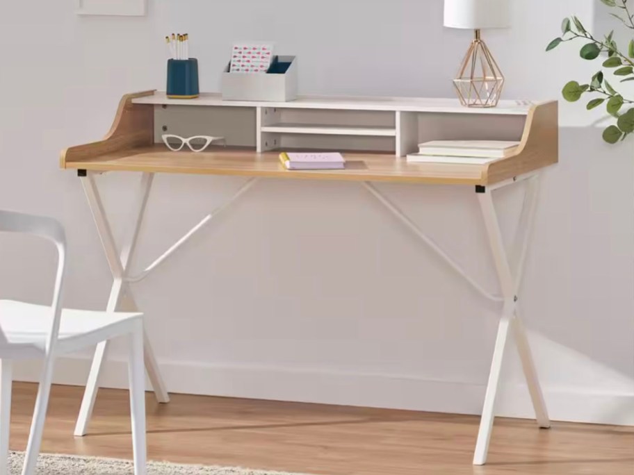 white and wood desk with lamp and school supplies sitting on top
