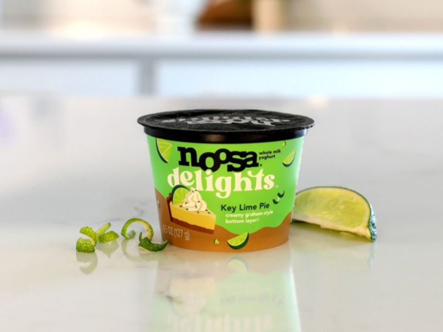 noosa delights yogurt on counter top next to lime