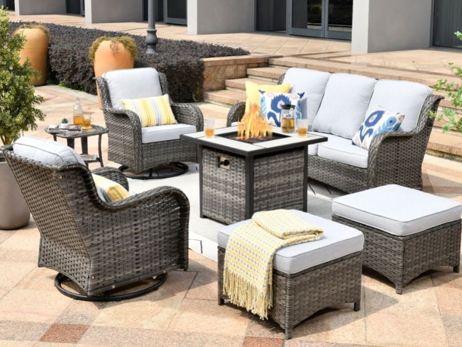 7 piece patio set with off white cushions arranged on a patio