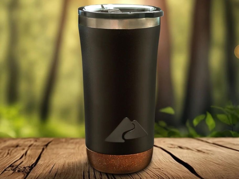 Ozark Trail 18 oz Insulated Stainless Steel Tumbler with Cork Bottom, Black on picnic table outside