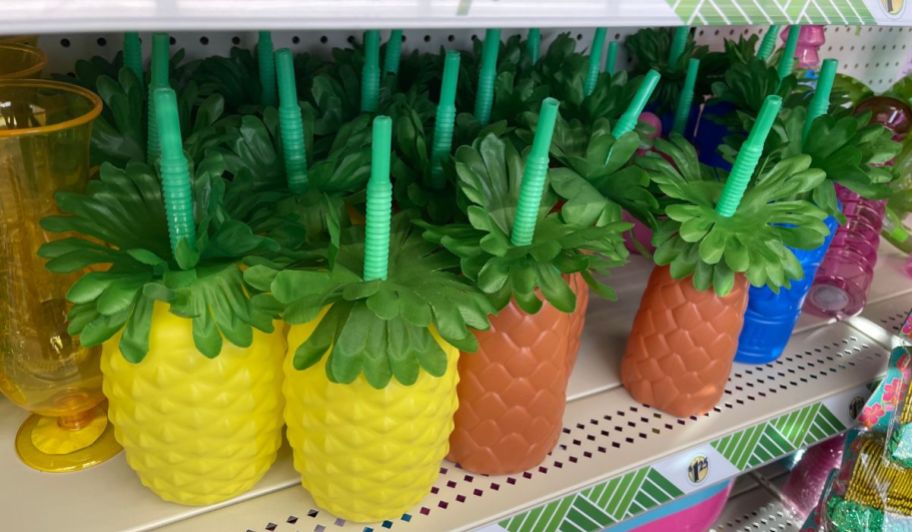 Plastic pineaple shaped cups with lids and straws on a store shelf
