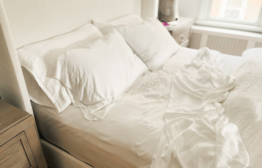 unmade bed with white sheets