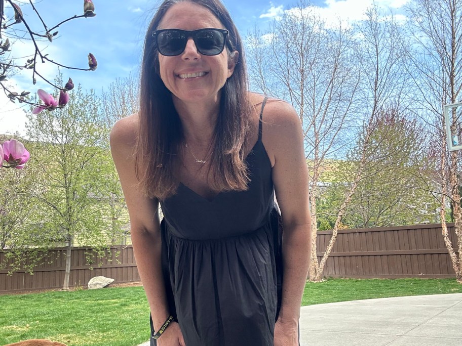 woman wearing black maxi dress and sunglasses looking into camera