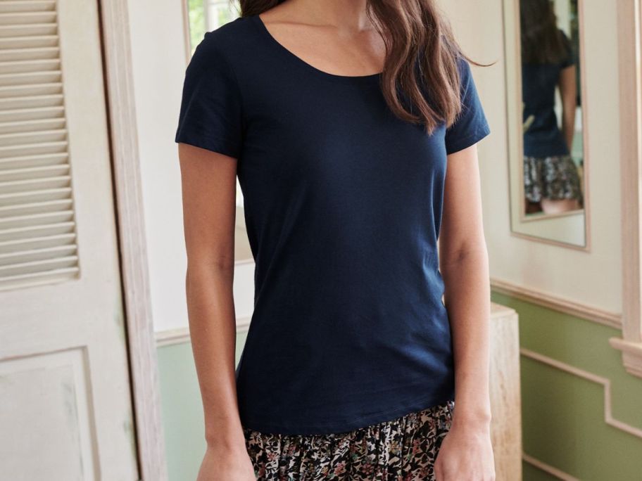 a woman wearing a navy blue scoop neck tee