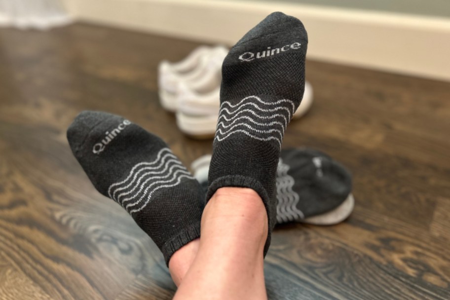 feet wearing black quince ankle socks next to socks