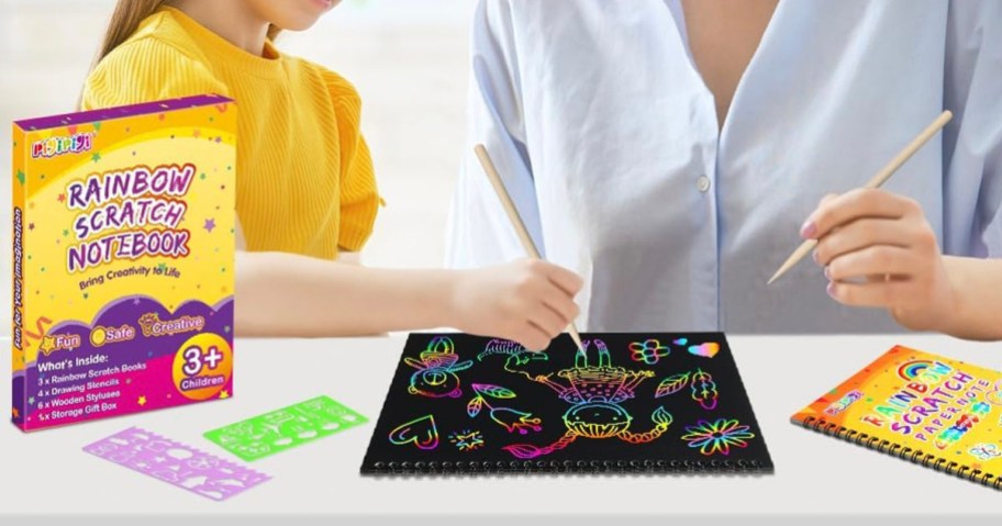 child and parent coloring on scratch art notebook at table