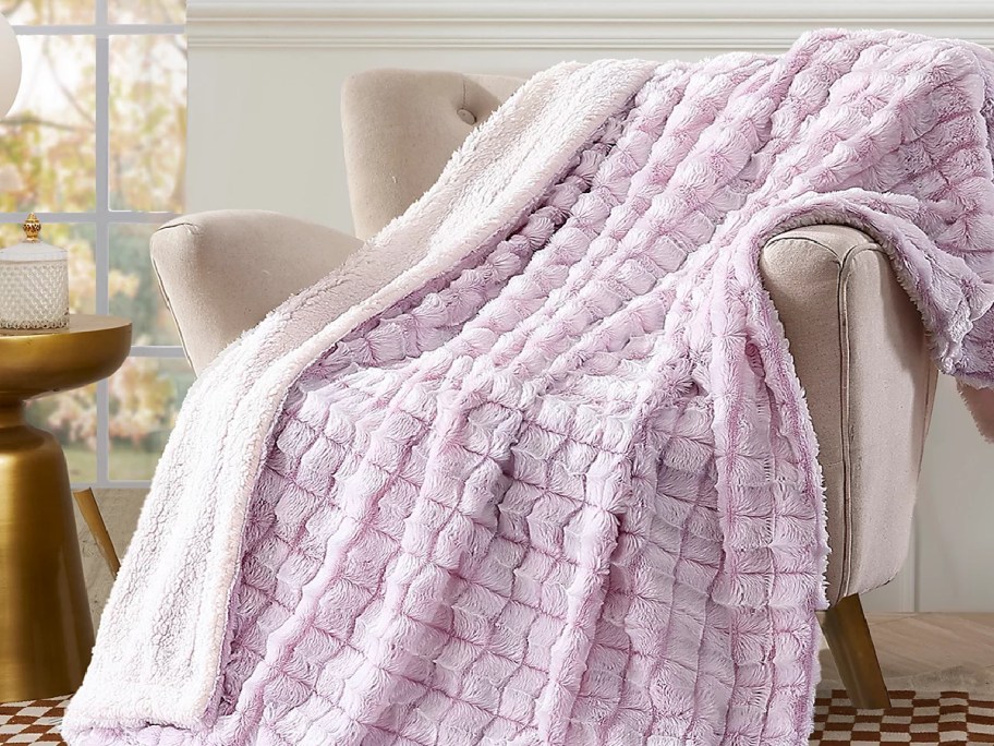 reverse pink throw blanket displayed on chair