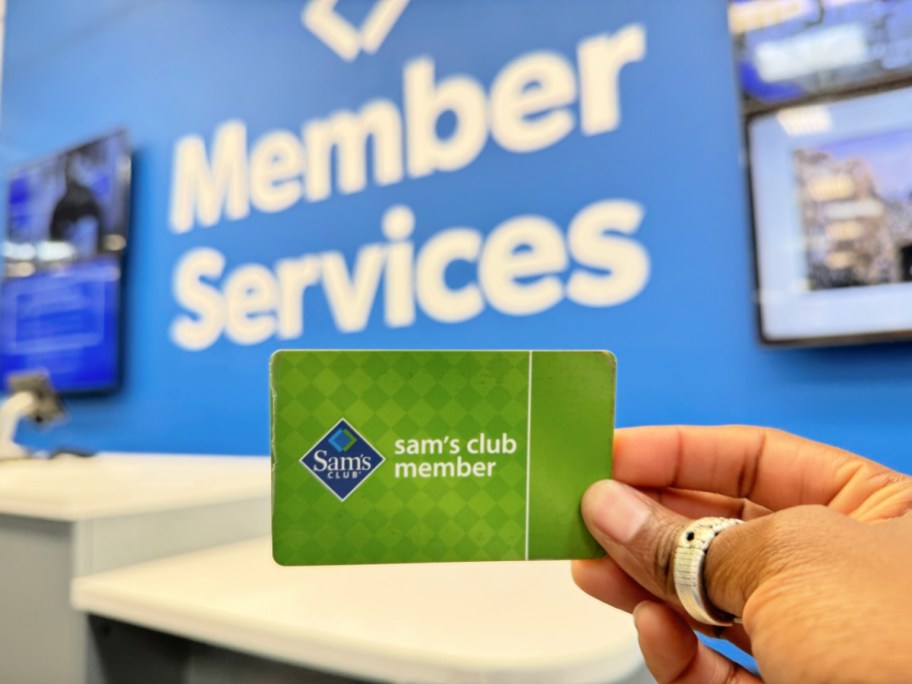 sam's club membership card in hand in front of a membership services sign