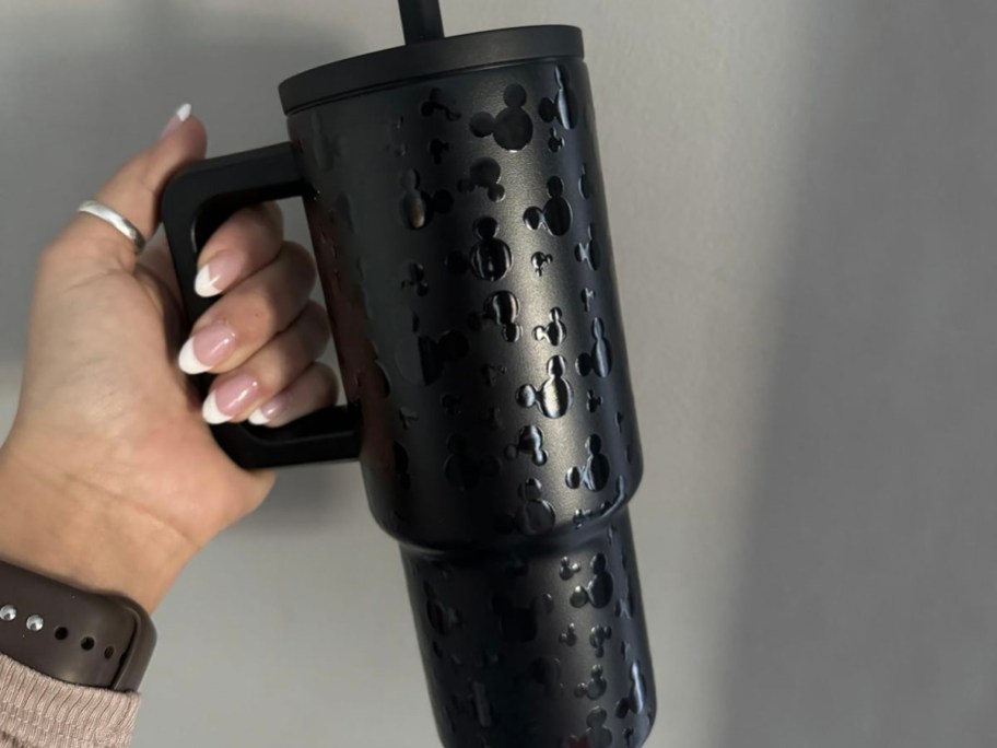 hand holding black mickey mouse tumbler