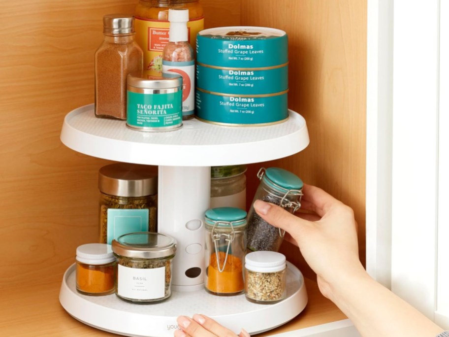 spices displayed on the lazy Susan with hand grabbing it