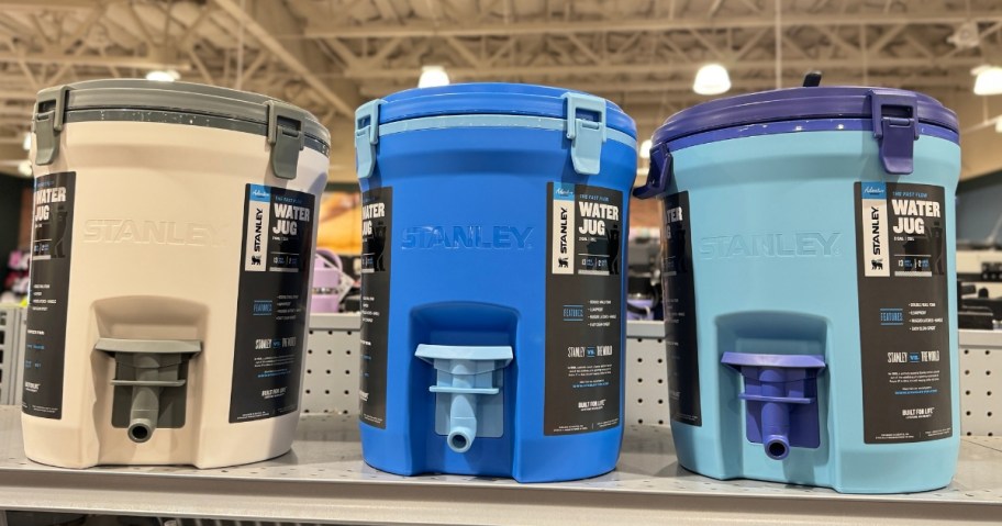 different color Stanley 2 gallon water jugs on shelf