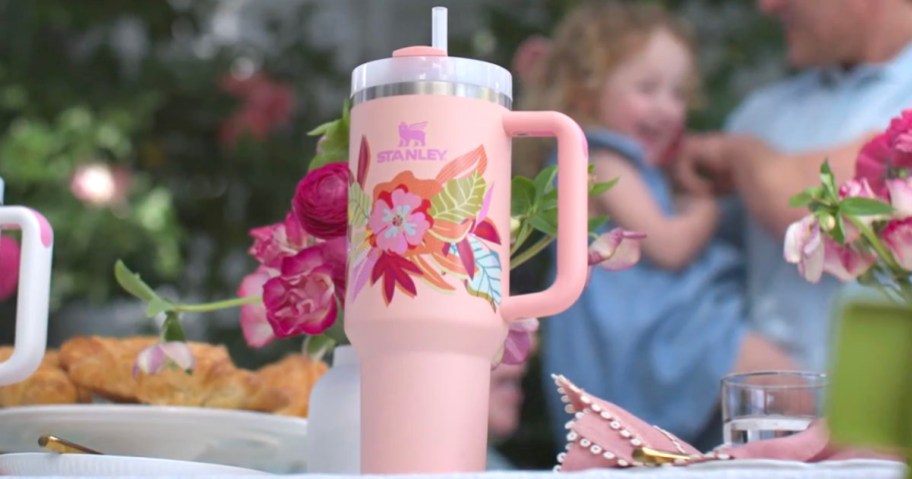 pink stanley floral mothers day mug sitting on table with food
