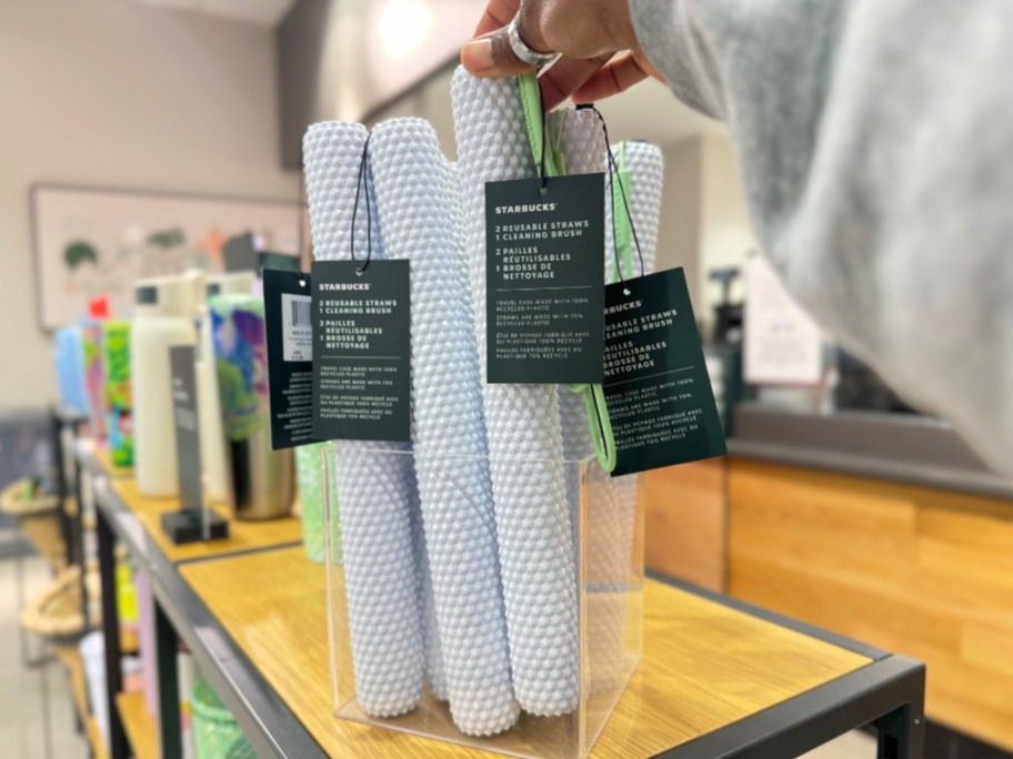 Starbucks reusable straws and cleaning brush with white studded case in a container on a shelf