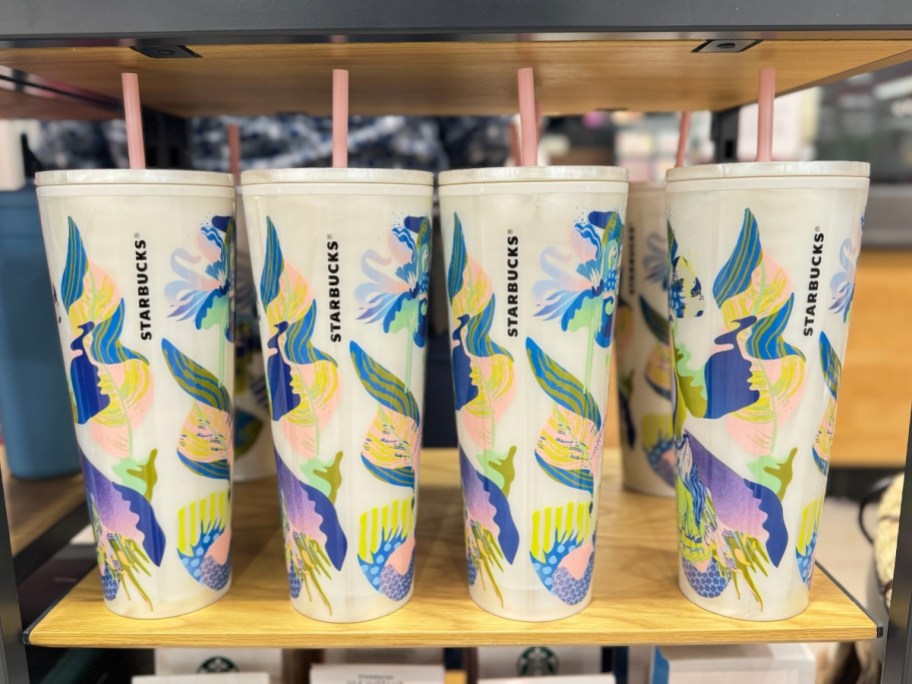 Starbucks straw tumblers with floral print on a shelf