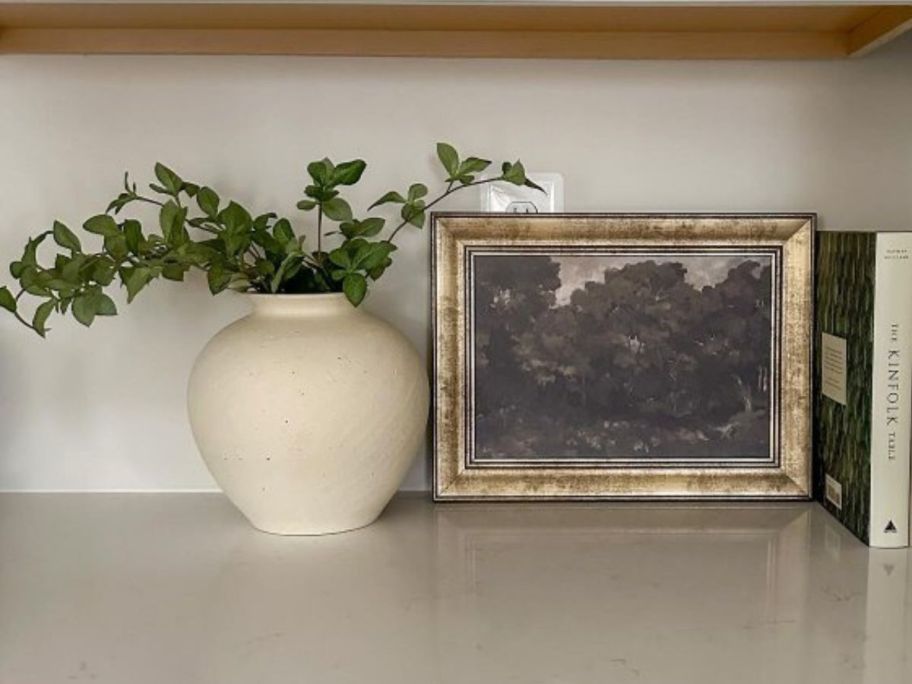 Hearth & Hand w/ Magnolia Faux Gypsophila Leaf Stem in vase on counter next to picture