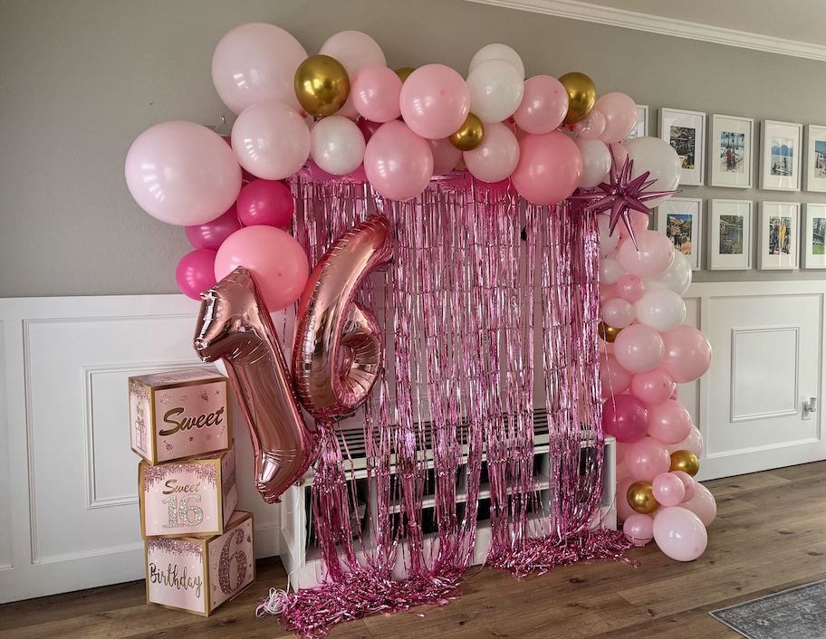 pink sweet 16 balloon arch and backdrop along wall