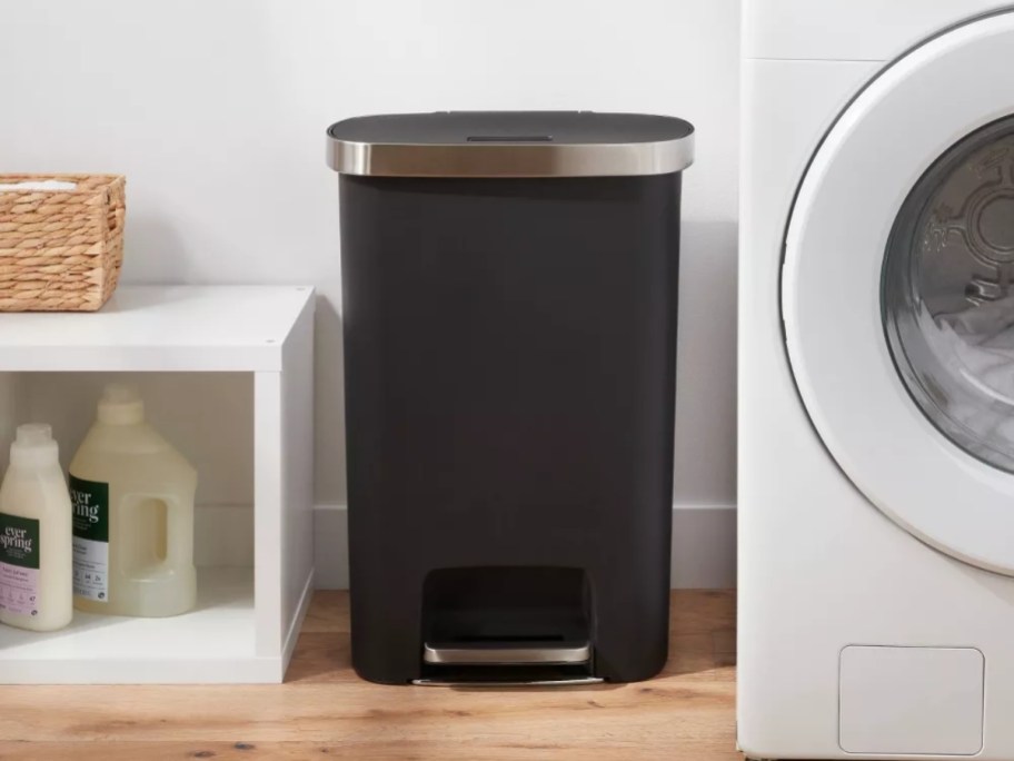 black and stainless steel trash can in a laundry room