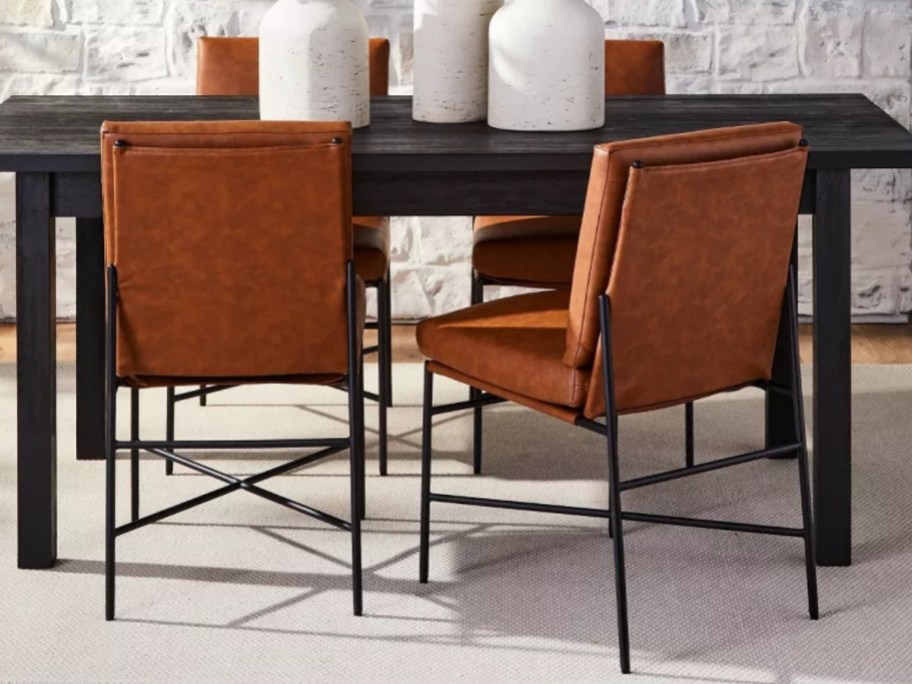 brown and black leather and metal dining chairs at a table