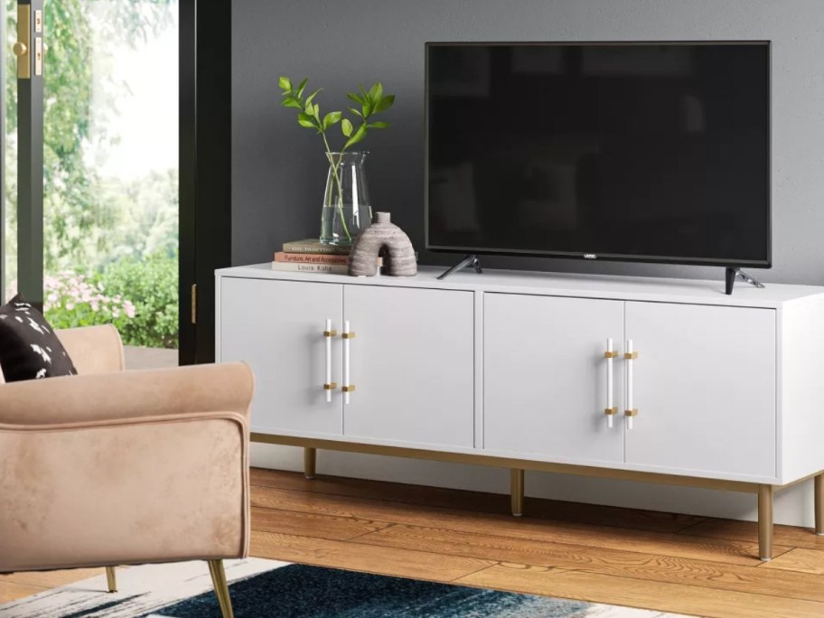 white and gold large TV stand in a living room