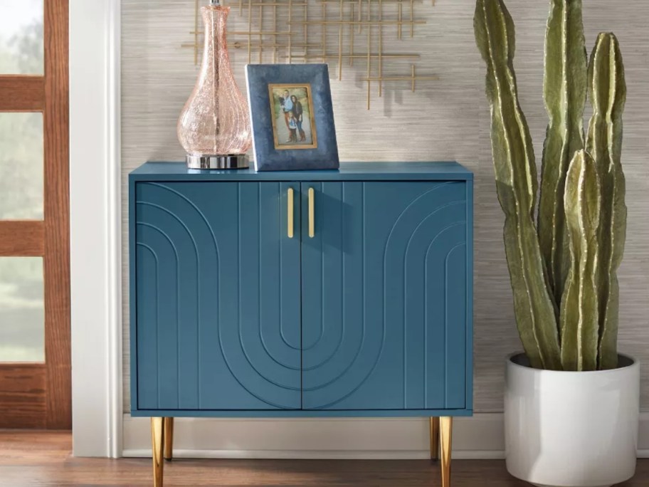 dark teal blue buffet with a lamp and photo frame on it in a living room
