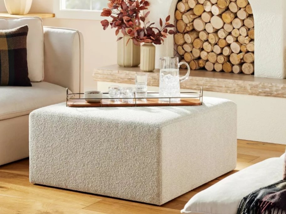 large off white square upholstered ottoman in a living room