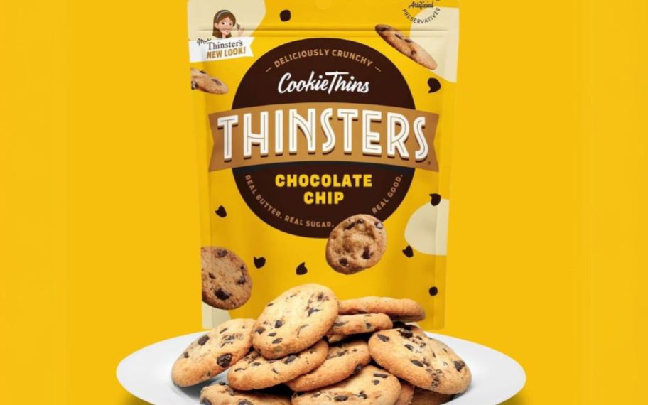 a bag of thinsters chocolate chip cookies with a plate filled with chocolate chip thinsters on a yellow background