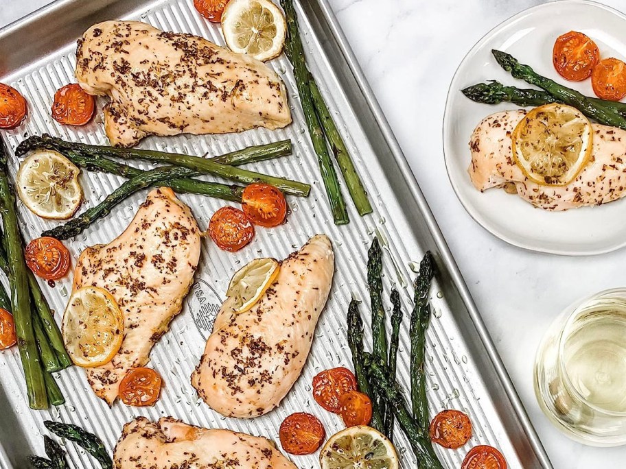 sheet pan with chicken and asparagus on it 
