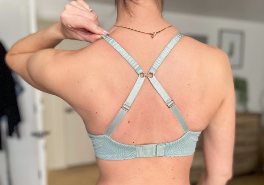 woman showing back of grey criss cross bra