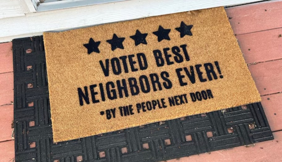 voted best neighbors ever by the people next door funny doormat on red wood deck