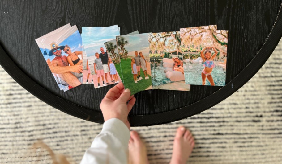 hand grabbing photo magnets off table