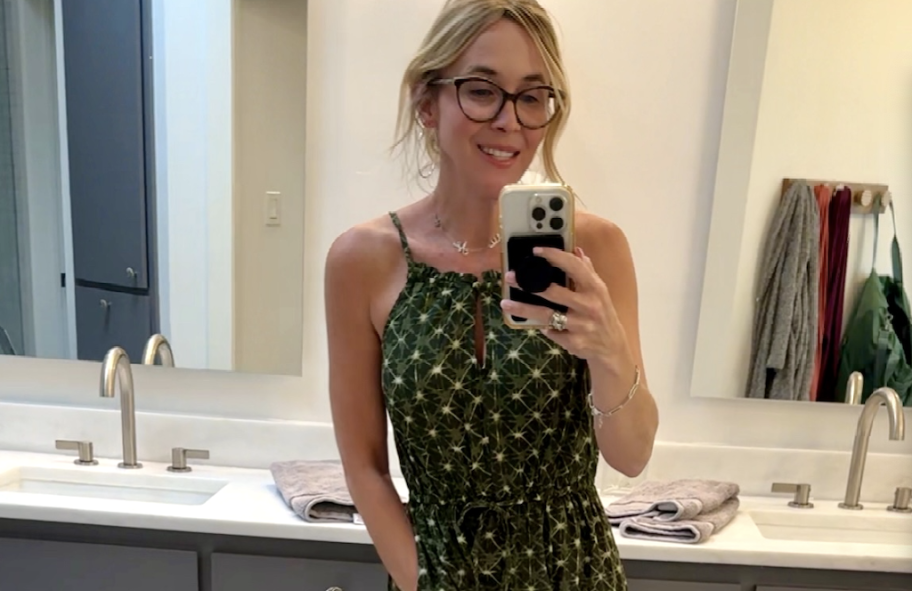 woman wearing green high neck dress in bathroom mirror