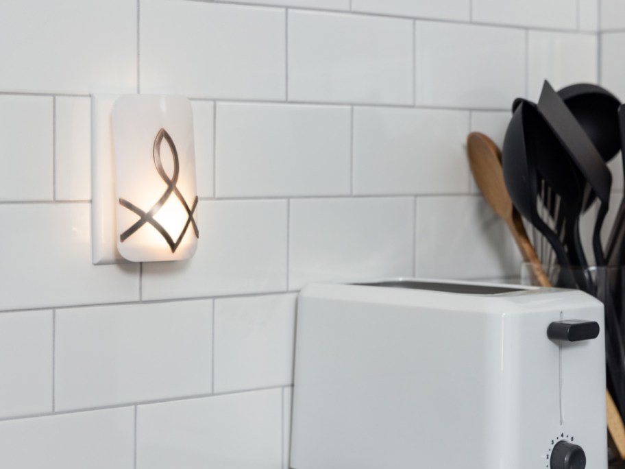 night light on white tile wall next to toaster