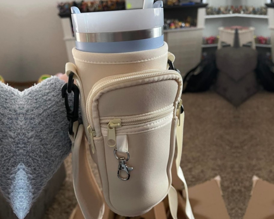 cream water bottle bag holding tumbler