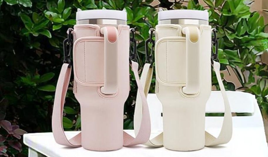 two water bottle crossbody bags in light pink and cream sitting on a patio table