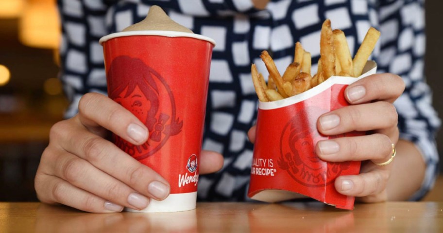 hands holding wendys frosty and fries