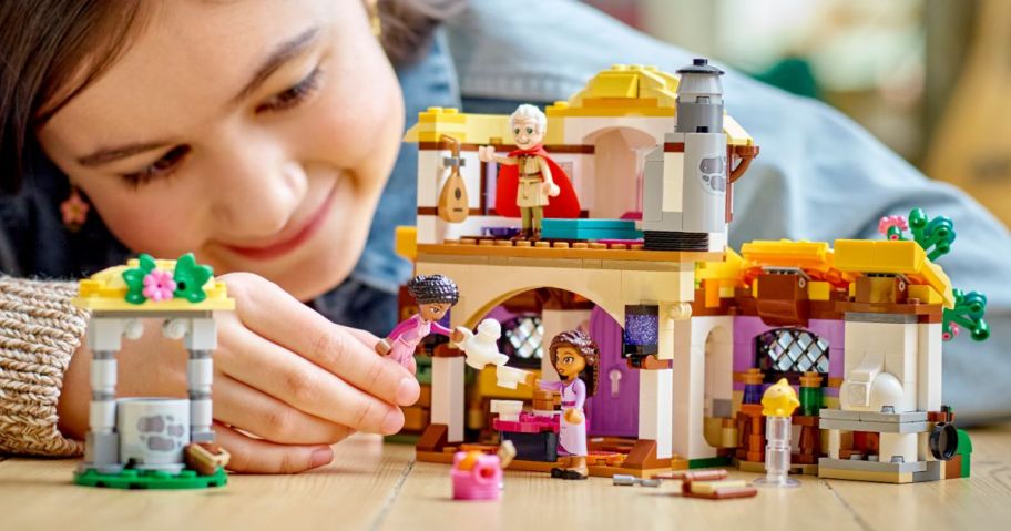 girl playing with LEGO Disney Wish: Asha’s Cottage