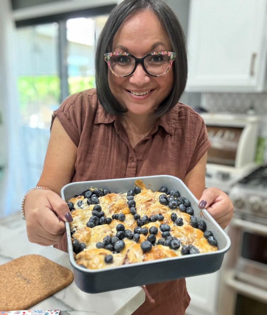 woman holding a blueberry lemon cinnamon roll breakfast cake