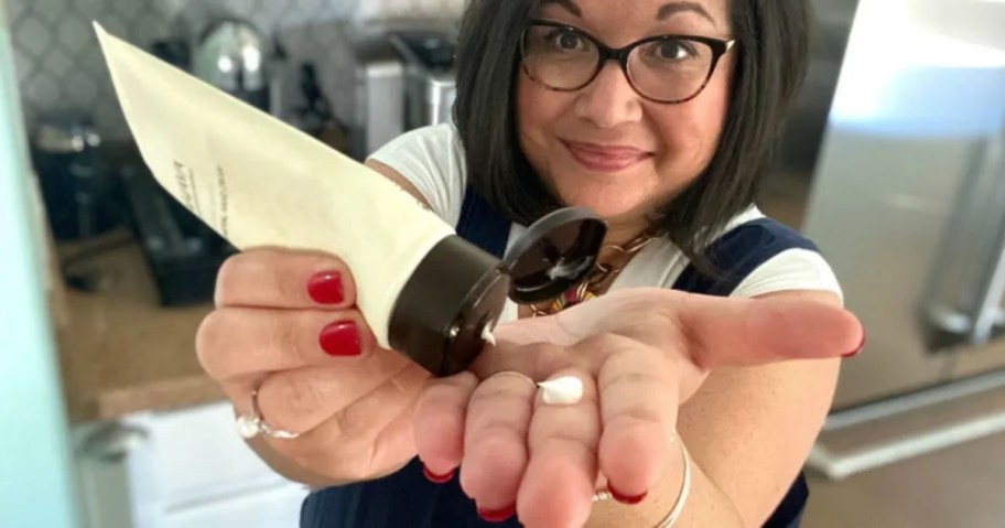 woman squeezing lotion on hands