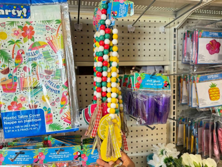 luau icon beads hanging on a pegboard in a store with assorted themed decorations