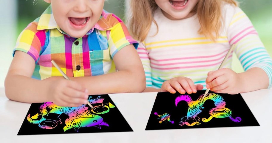 girl and boy using scratch art on table