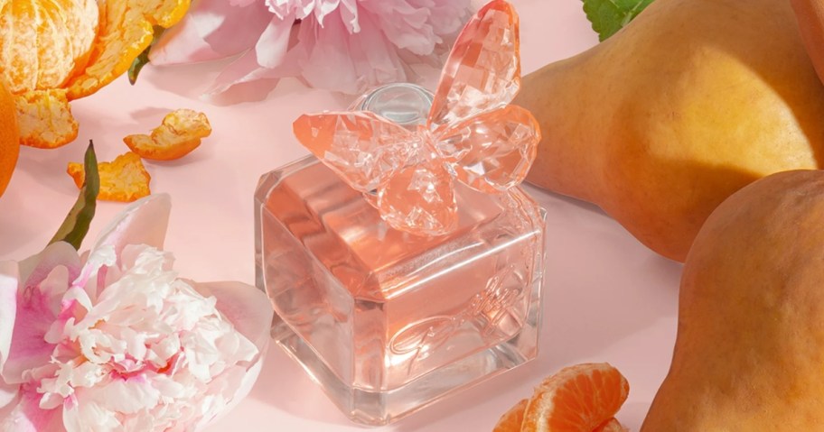 pink glass Perfume bottle with a pink butterfly on the lid surrounded by flowers and fruit