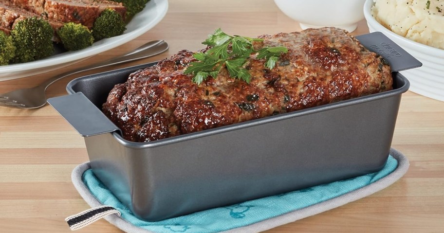 meatloaf in a loaf pan with lifter on a kitchen table