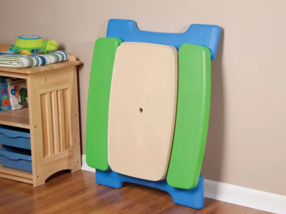 folded up Little Tikes Easy Store Jr. Play Table leaning against a wall