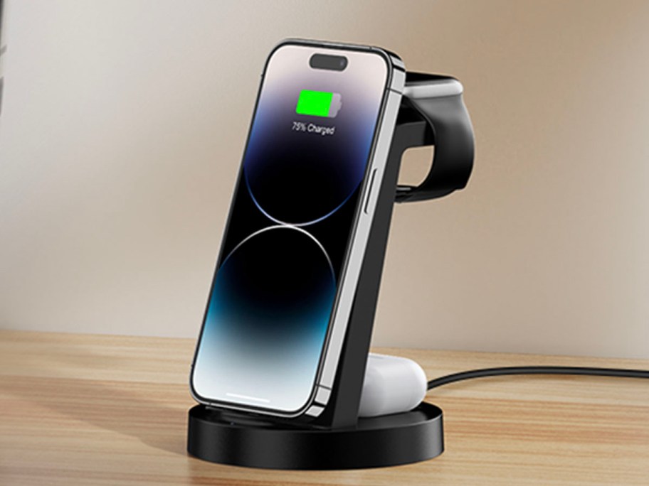 black charging station with phone airpods and watch on it charging
